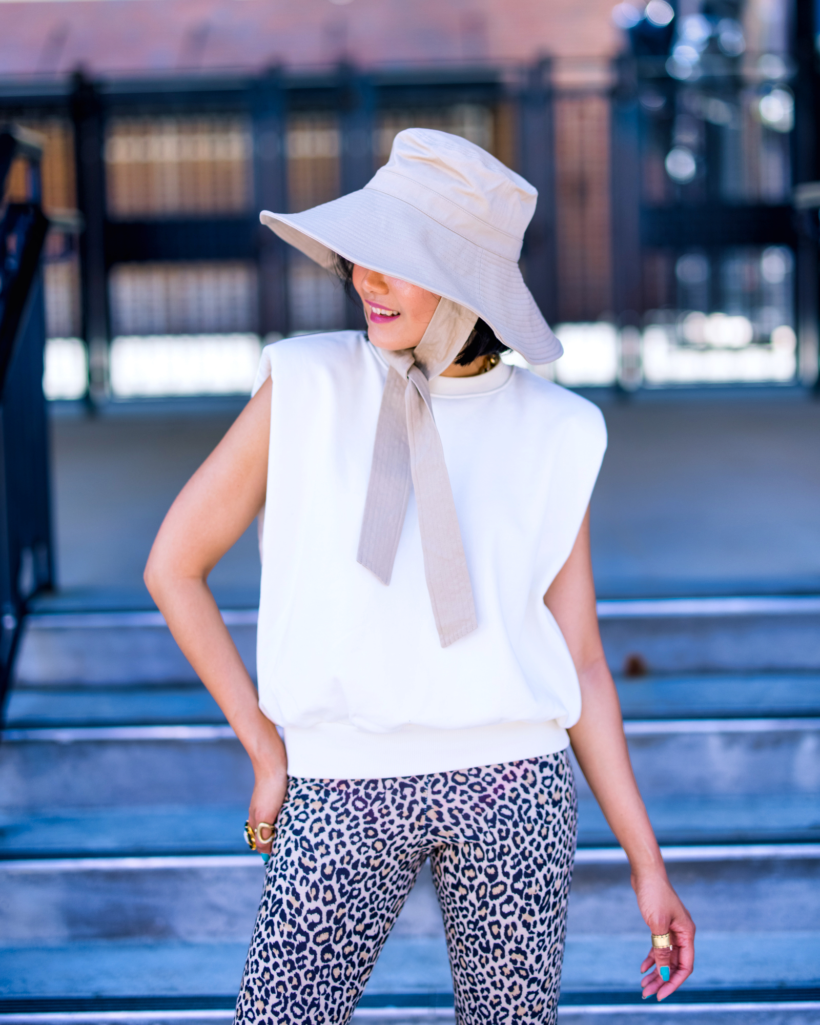 nanphanita jacob is channeling 90s fashion with a shoulder-pad tee with leopard pants and top off with a plain canvas bucket hat by san diego hat company